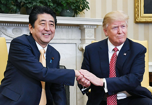 ２月の日米首脳会談でトランプ米大統領（右）と握手する安倍首相＝ワシントンのホワイトハウス（共同）